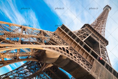 عکس با کیفیت ساختار برج ایفل از نمای پایین و آسمان آبی
