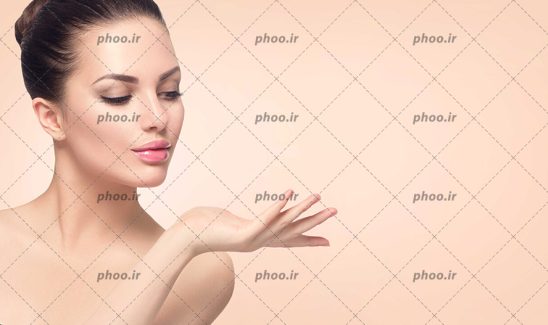 عکس با کیفیت زن زیبا با چهره ی نچرال و پوست شفاف با ژست گرفتن دست خود در کنار صورتش