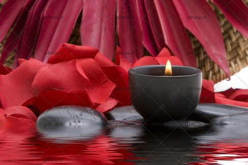 عکس شمع و گلبرگ رز قرمز در اسپا