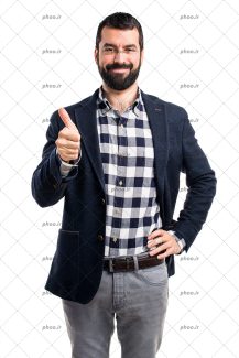 عکس مرد با لبخند و دست به کمر و نشان دادن علامت لایک با دست دیگر در پس زمینه سفید