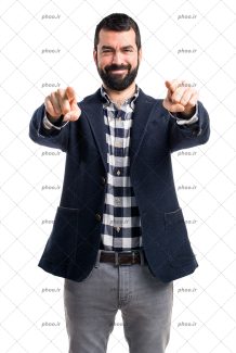 عکس مرد با لبخند و کت در حال اشاره کردن به دوربین با دو دست