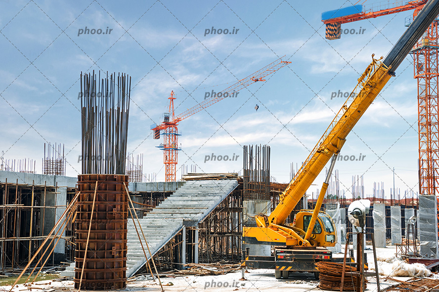 عکس با کیفیت ساختمان در حال ساخت و جرثقیل در برابر آسمان آبی