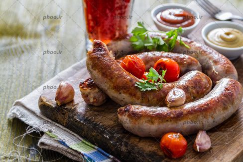 عکس سوسیس کبابی در کنار سس و نوشابه