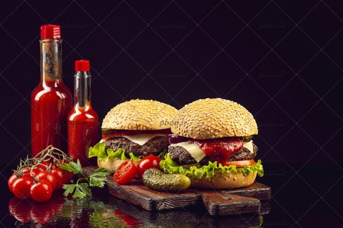 عکس ساندویچ همبرگر با نون تست و سس ها و زمینه مشکی