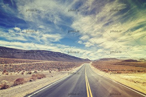 عکس بزرگراه در کویر در برابر آسمان ابری