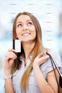 عکس با کیفیت خانم در حال فکر کردن با کارت اعتباری و کیسه های خرید در دست