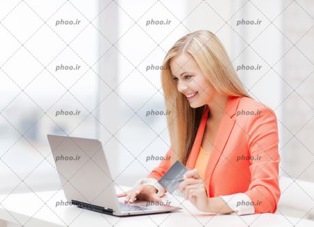 عکس با کیفیت خانم زیبا در حال کار با لپ تاپ و کارت اعتباری در دست