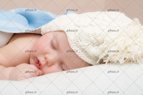 عکس نوزاد و کودک کلاه دار خوابیده بین پتو