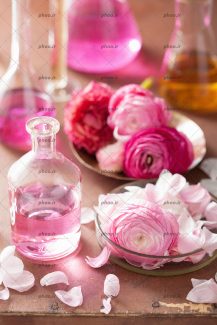 عکس کیمیا و مجموعه ای آروماتراپی با گل رز و بطری شیشه ای از نمای نزدیک