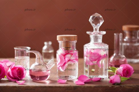 عکس کیمیا و مجموعه ای آروماتراپی با گل رز و بطری شیشه ای