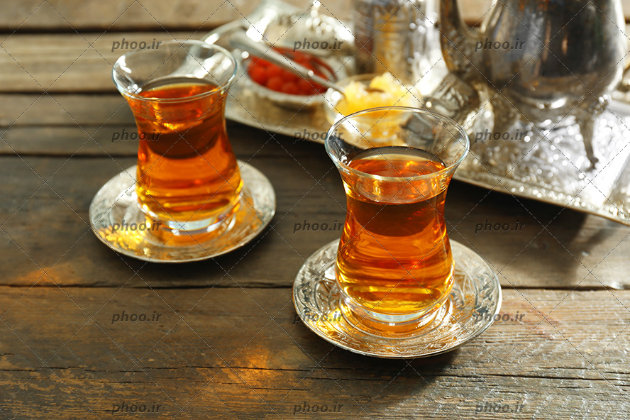 عکس دو فنجان چای در پس زمینه چوبی