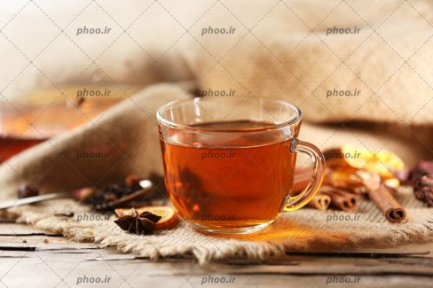 عکس یک فنجان چای در پس زمینه گونی کنفی