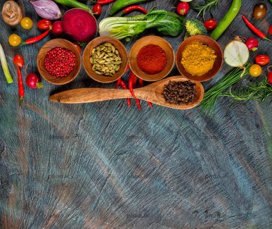 عکس ادویه هایی در کاسه های چوبی در کنار سبزیجات از نمای بالا