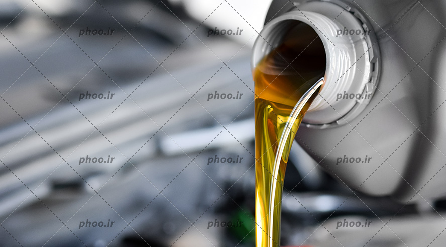 عکس ریختن روغن از بطری و تعویض روغن ماشین از نمای نزدیک