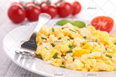 عکس صبحانه تخم مرغ با سبزی و گوجه فرنگی در بشقاب با پس زمینه چوبی