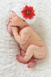 عکس با کیفیت نوزاد تازه متولد شده خواب با کلاه بافتنی در پس زمینه سفید