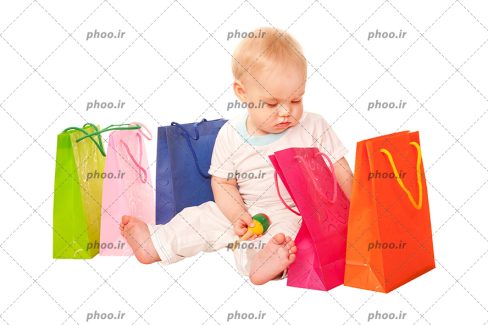 عکس با کیفیت کودک نشسته در کنار کیسه های خرید رنگی در پس زمینه سفید
