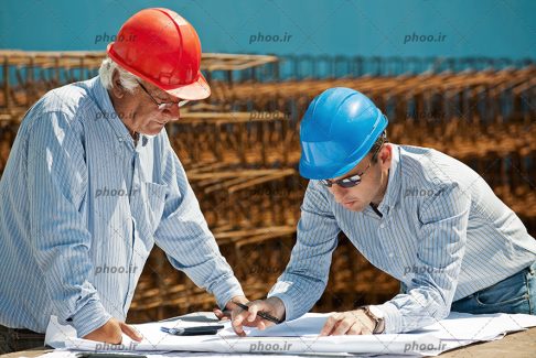 عکس مهندسان درحال خواندن نقشه و طراحی