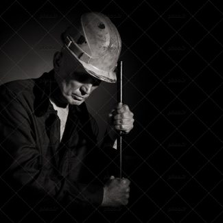 عکس کارگر مرد درحال کار با کلاه ایمنی و تم خاکستری