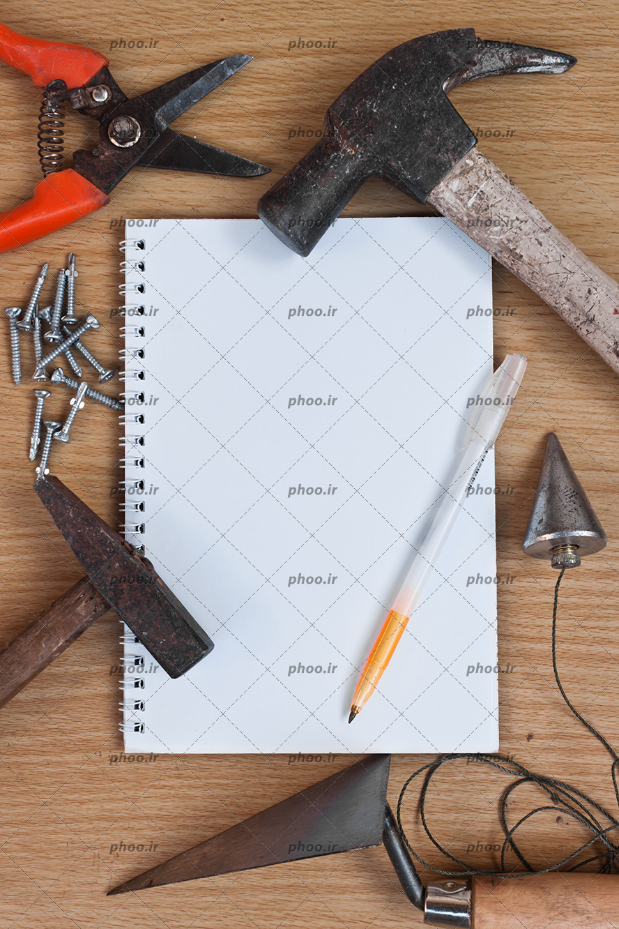 عکس ابزار های مختلف و دفترچه یادداشت و خودکار روی زمینه چوبی