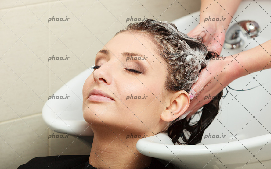 عکس مشتری درحال شستشو موهایش در آرایشگاه