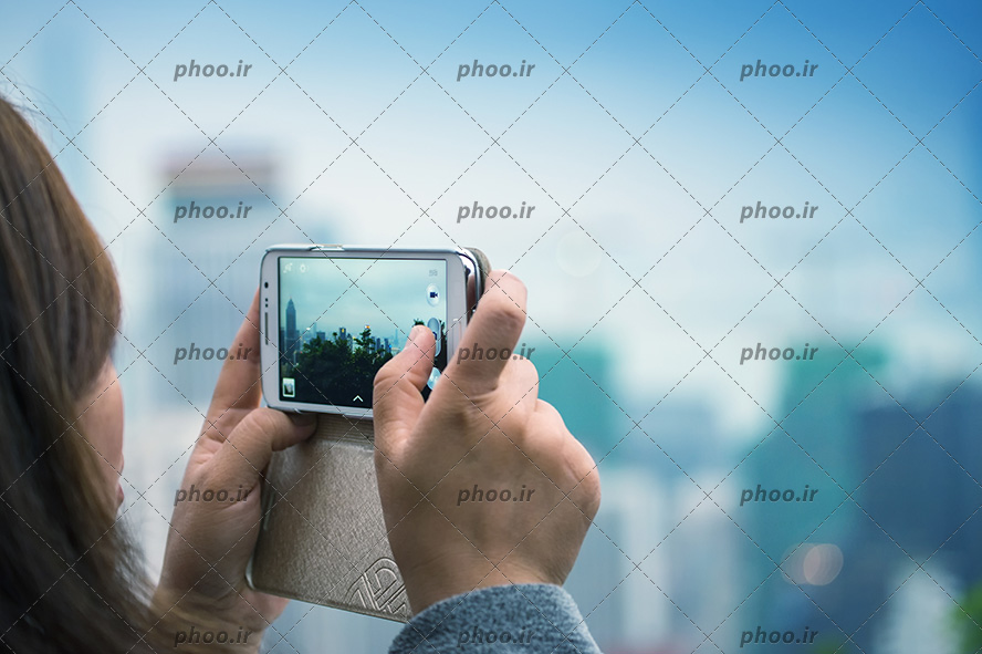 عکس با کیفیت دختر در حال عکاسی با موبایل از طبیعت