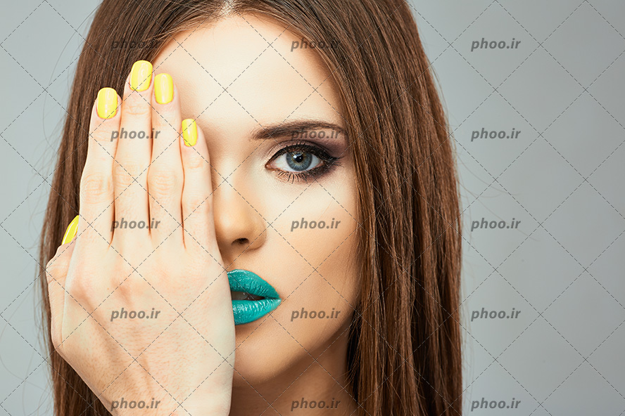 عکس خانم با مو های قهوه ای و آرایش و مانیکور به رنگ زرد