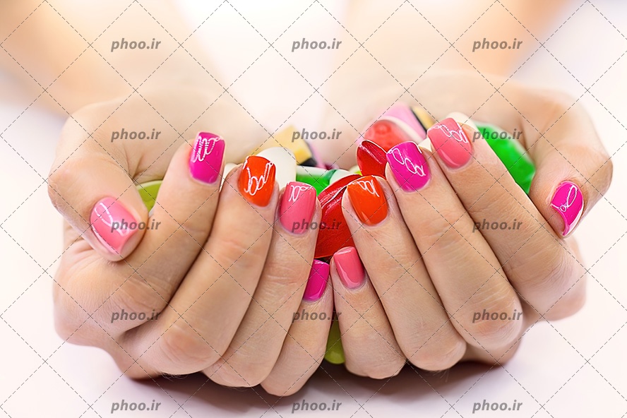 عکس شیرینی ژله چند رنگ در دست خانمی با رنگ ناخن روشن