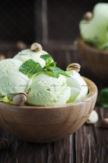 عکس بستنی نعنایی اسکوپی تزئین شده با پسته در کاسه چوبی