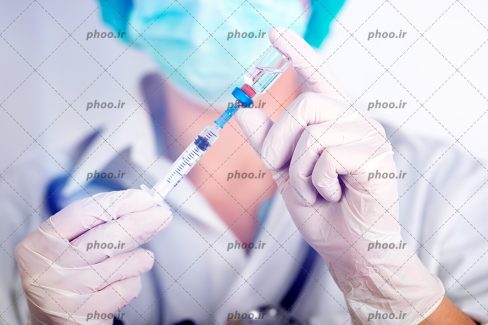 عکس با کیفیت خانم دکتر در حال آماده کردن سرنگ برای تزریقات