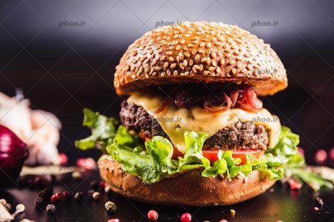 عکس ساندویچ همبرگر با نون تست و سس ها و زمینه مشکی محو