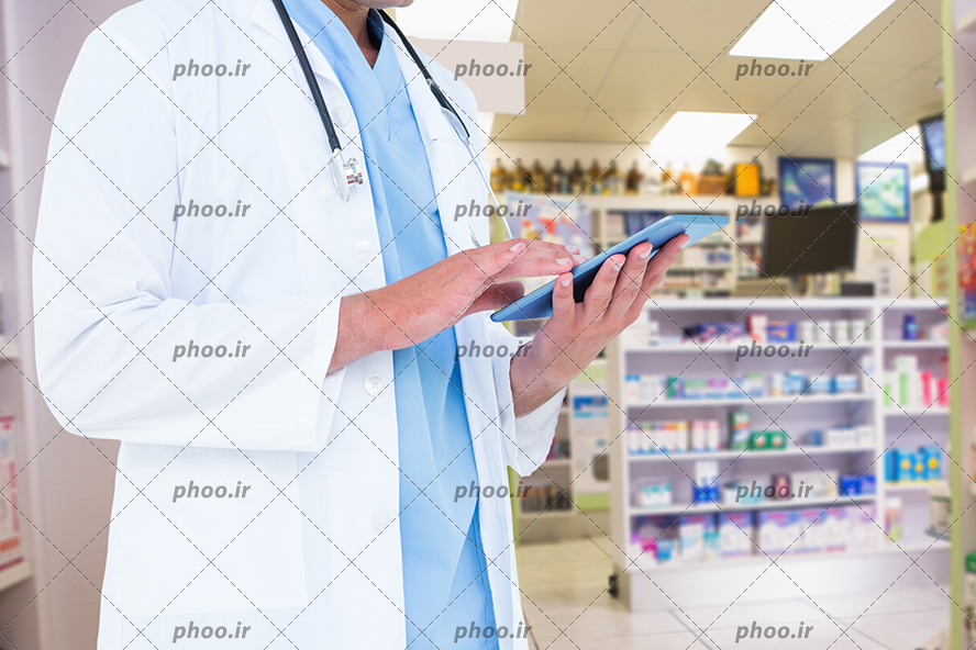 عکس با کیفیت تبلت در دست پزشک داروخانه در حال برسی موجودی دارو ها