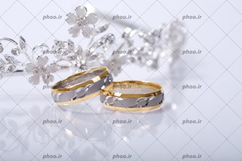 عکس با کیفیت دو حلقه ست به رنگ طلایی و نقره ای در کنار یکدیگر