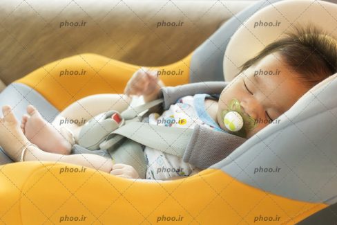 عکس نوزاد خواب روی صندلی کودک در ماشین