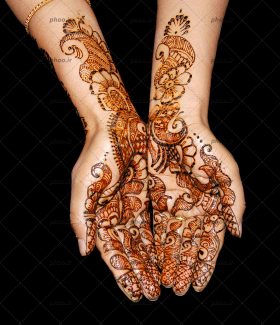 عکس طراحی با حنا روی دست در برابر یک پس زمینه سیاه