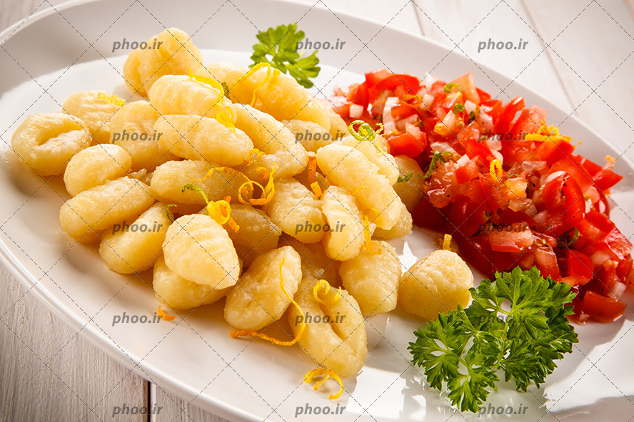 عکس پاستا در کنار گوجه و سبزی در ظرف سفید