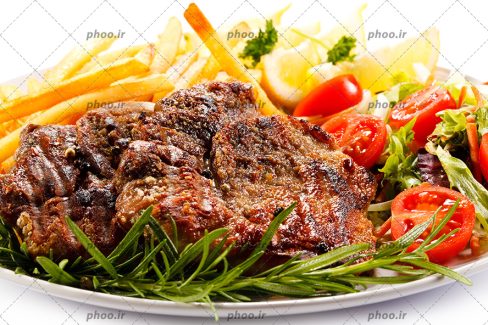عکس استیک کبابی، سیب زمینی سرخ کرده و سبزیجات در پس زمینه سفید