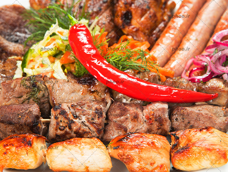 عکس گوشت های کباب شده و سبزی و فلفل تند روی آن ها