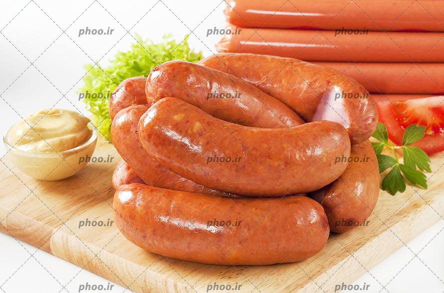 عکس سوسیس ها و سس و سبزیجات روی تخته چوبی در پس زمینه سفید