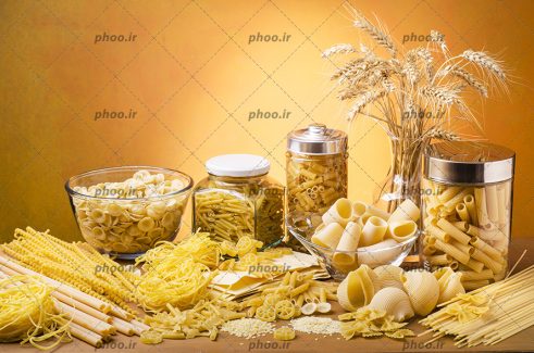 عکس ماکارونی های خام با شکل های متفاوت در پس زمینه قهوه ای روشن