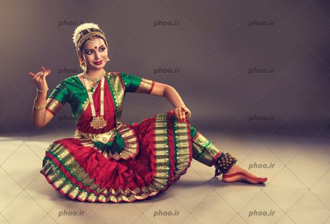 عکس دختر هندی با آرایش و لباس سنتی با ژست نشسته روی زمین