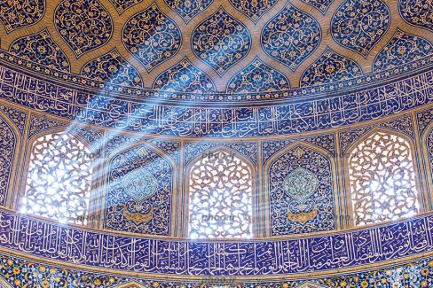 عکس نمای داخلی مسجد با گنبد کاشی کاری شده زیبا با آیات قرآن و پنجره های چوبی که از آن نور به زیبایی در جهت های مختلف به داخل تابیده شده