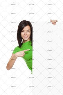 عکس زن شاد با تی شرت سبز در حال اشاره کردن به بنر سفید خالی