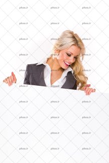 عکس با کیفیت خانم زیبا با مو های طلایی پشت تابلوی سفید در حال نگاه کردن به آن