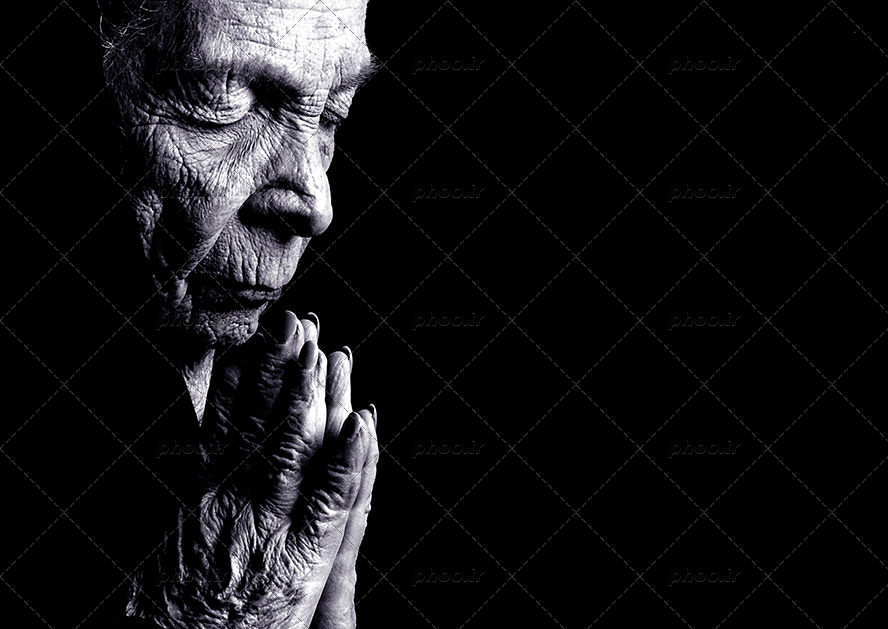 عکس با کیفیت پرتره پیر زن در تاریکی در حال دعا