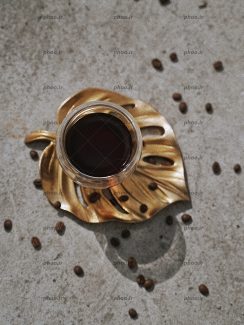 عکس خوشمزه قهوه در فنجان روی برگ طلایی