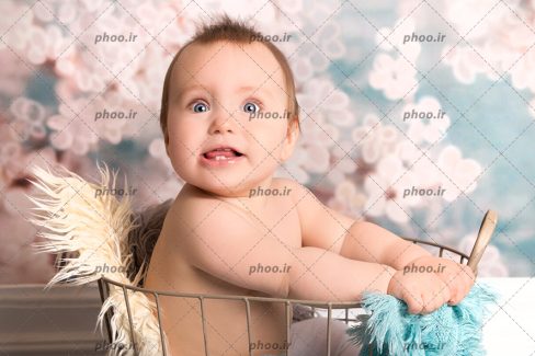 عکس نوزاد خوشحال در سبد با زمینه محو