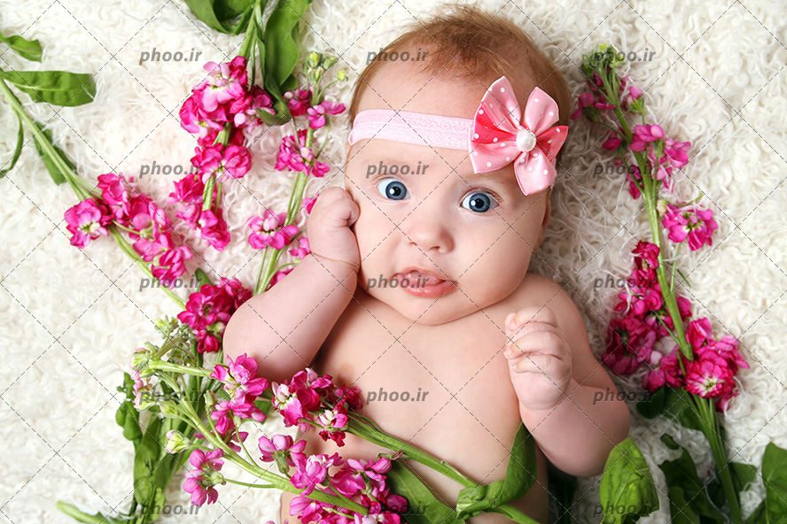 عکس نوزاد و کودک تل دار خوابیده روی خز و کنار گل ها