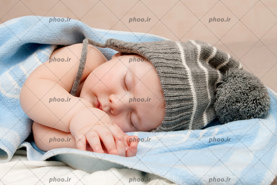 عکس نوزاد و کودک کلاه دار خوابیده بین پتو