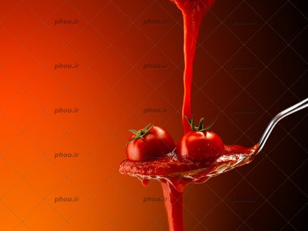 عکس گوجه و سس داخل قاشق از زاویه نزدیک و زمینه قرمز